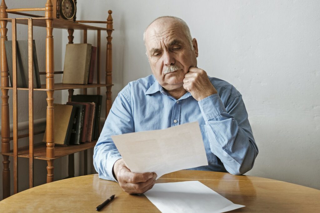 Thoughtful old man reading a paper document