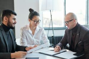 Mature agent consulting his business partners looking through financial contract